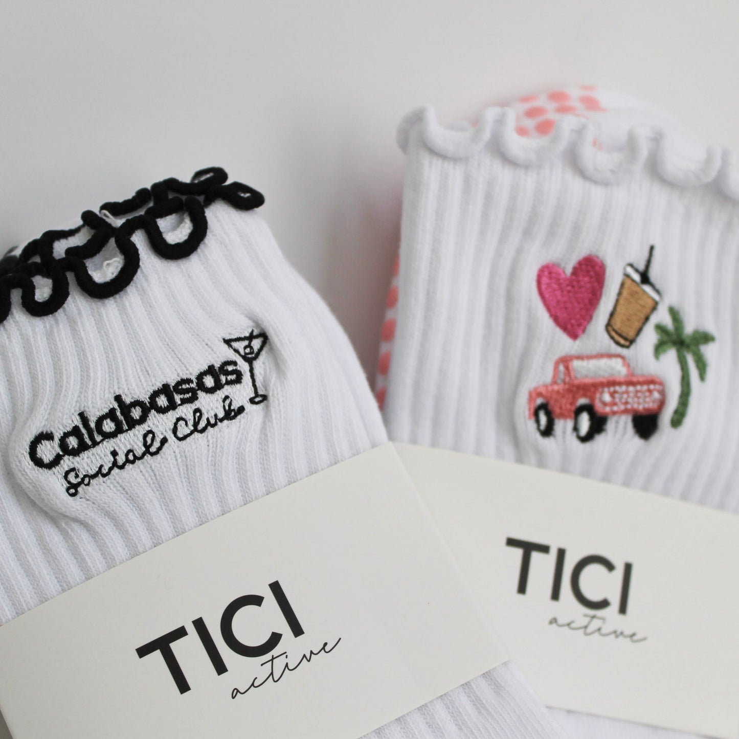 Two pairs of socks with text and graphics on a white background. tici active grip socks, west coast duo