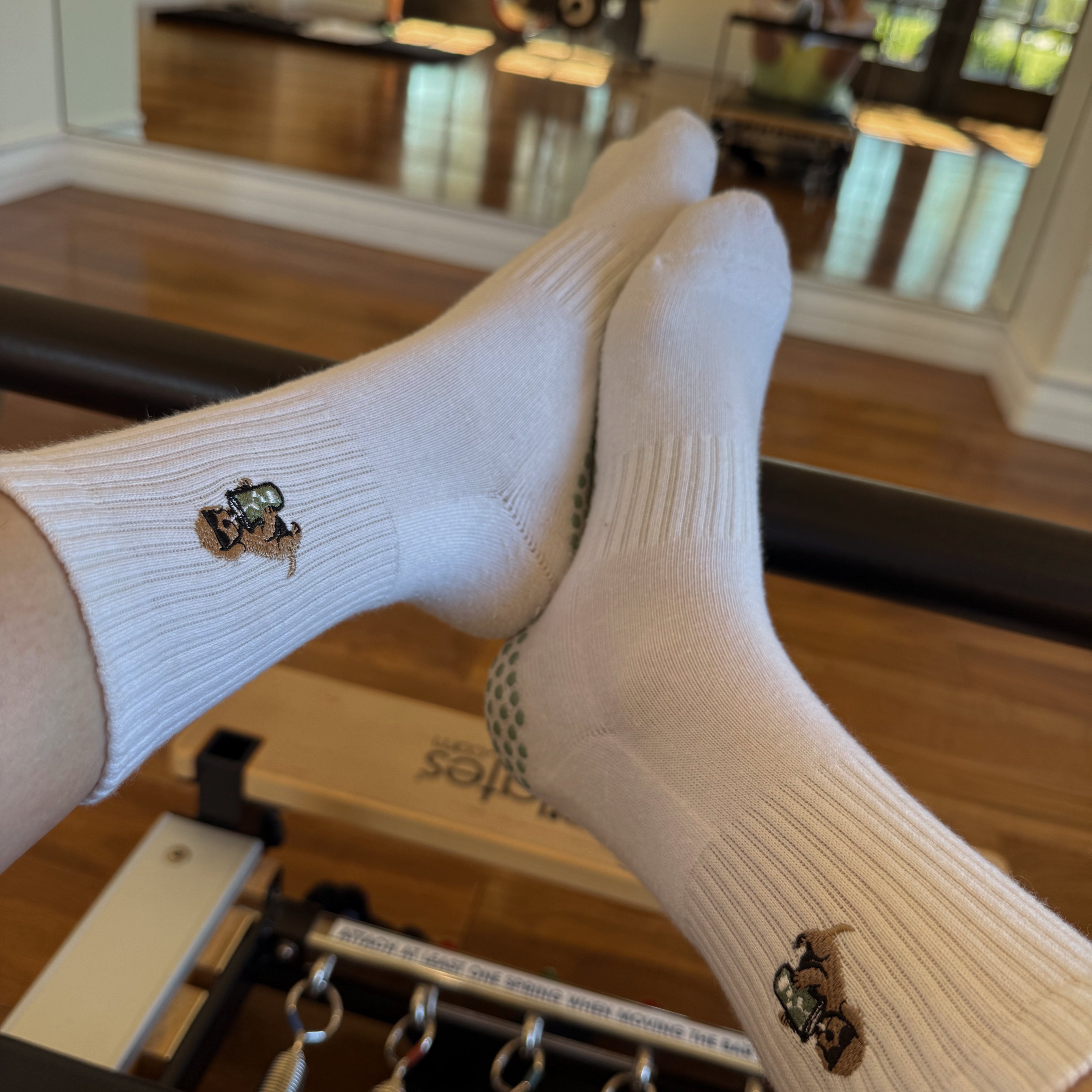 White TICI ACTIVE non-slip Pilates socks with full-sole grip on a reformer