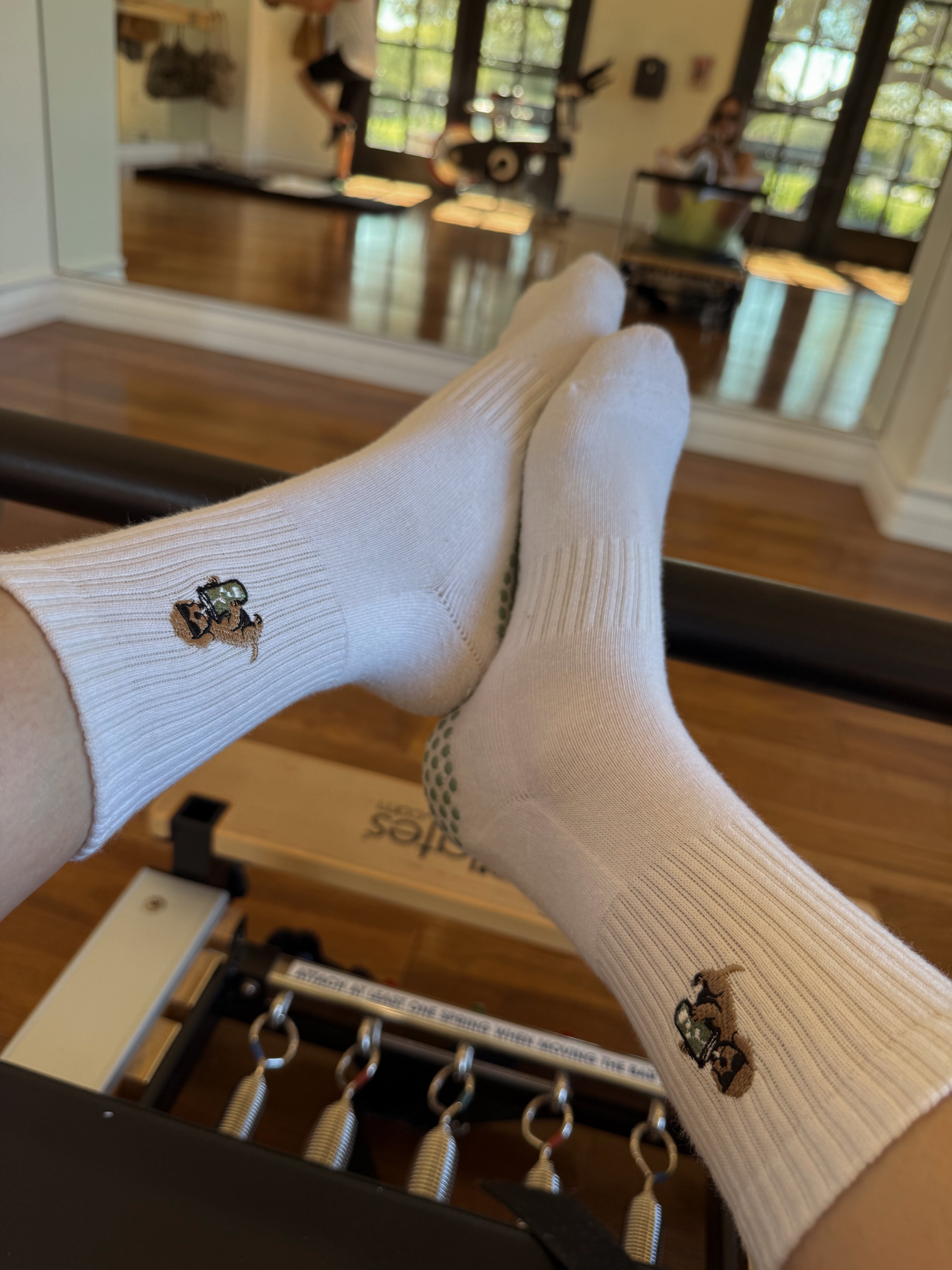 White TICI ACTIVE non-slip Pilates socks with full-sole grip on a reformer