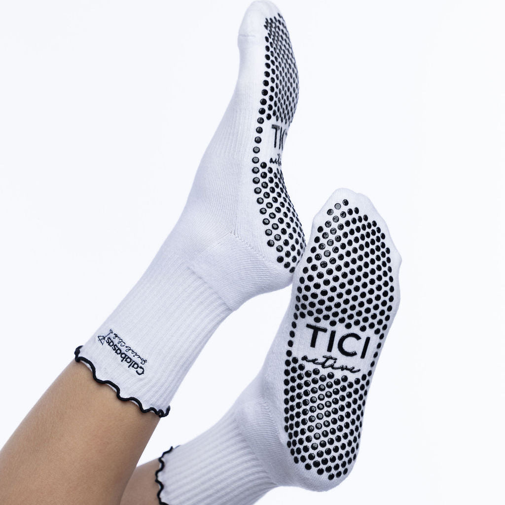 White socks with black grip sole and tici active branding on a white background grip socks 