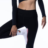 Person wearing black athletic leggings and a black long-sleeve top on a white background tici active grip sock mom socks 