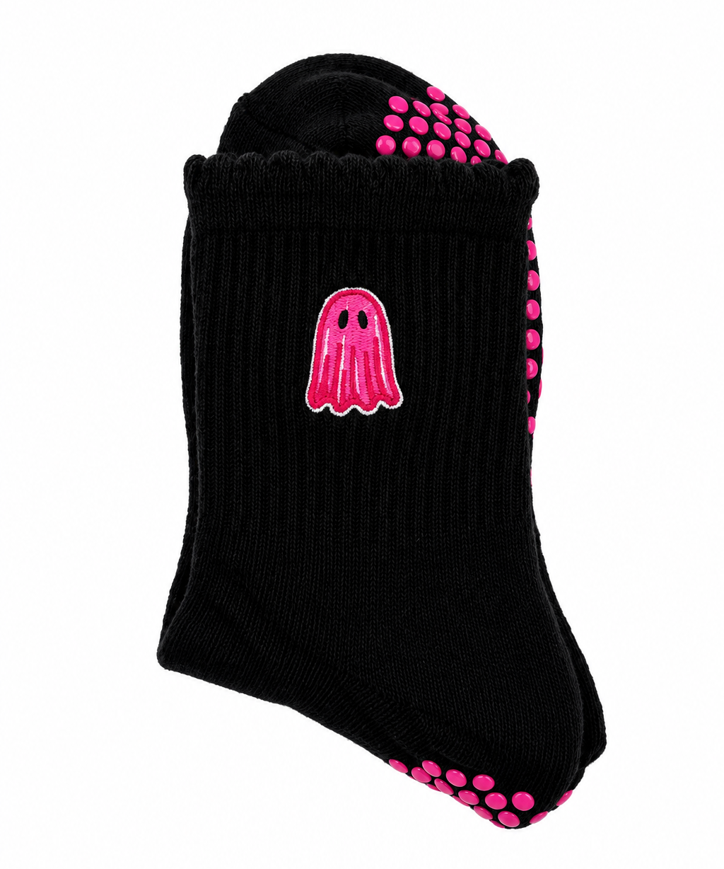 A single black ribbed ankle sock with a pink ghost graphic on the side and pink grip dots on the sole and heel, shown on a plain white background.