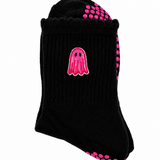 A single black ribbed ankle sock with a pink ghost graphic on the side and pink grip dots on the sole and heel, shown on a plain white background.