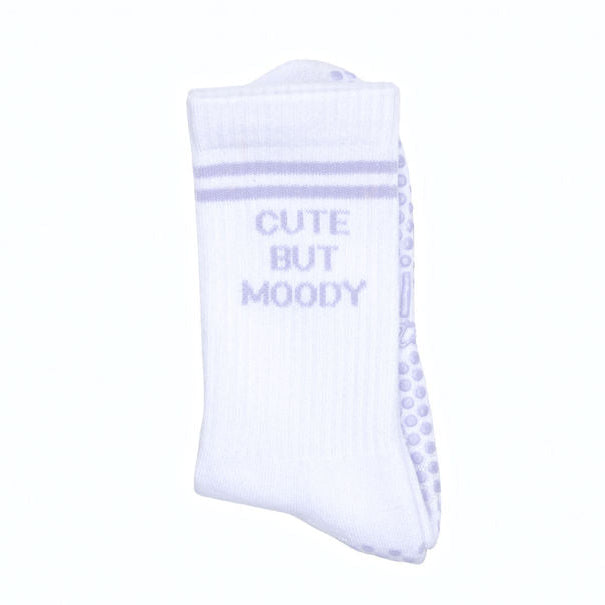 White pilates socks with lavender grips and text that read, "CUTE BUT MOODY"