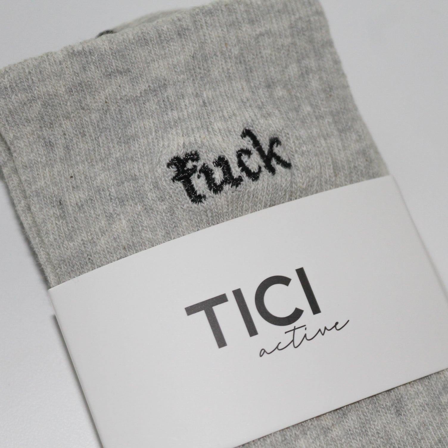 Gray grip socks with black text and 'TICI ACTIVE'  branding on a white background. Grip socks are heather gray with black grips. 
