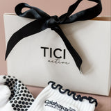 White socks with black accents and a black bow on a beige background