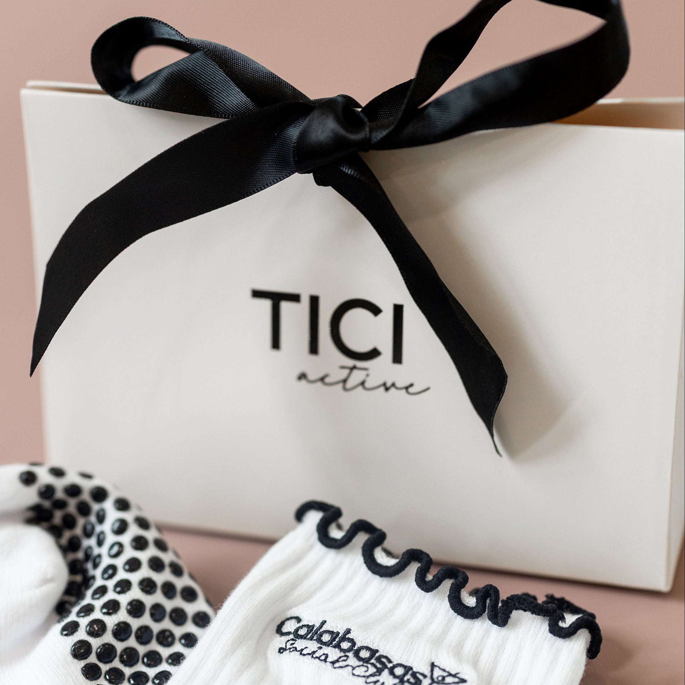 White socks with black accents and a black bow on a beige background