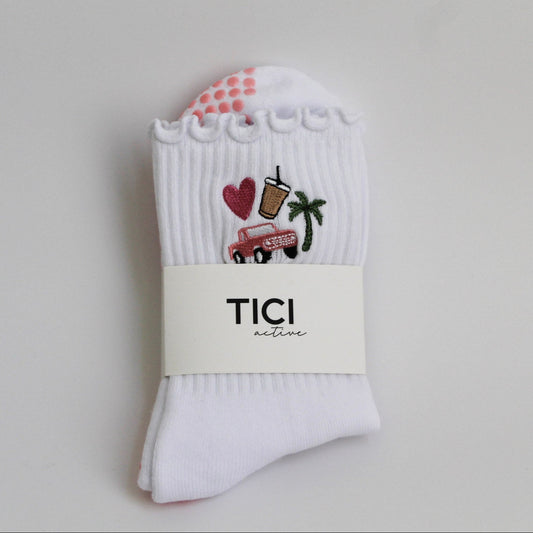 White socks with colorful designs and 'TICI active' branding on a light gray background. tici active grip socks. california dreamin