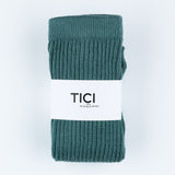 Teal ribbed socks with a white label on a light gray background tici active grip socks 
