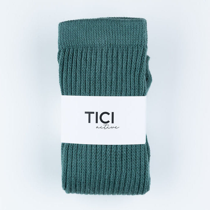 Teal ribbed socks with a white label on a light gray background tici active grip socks 
