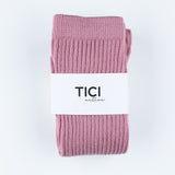 Pink ribbed socks with a white label featuring 'TICI' on a light gray grip socks  background