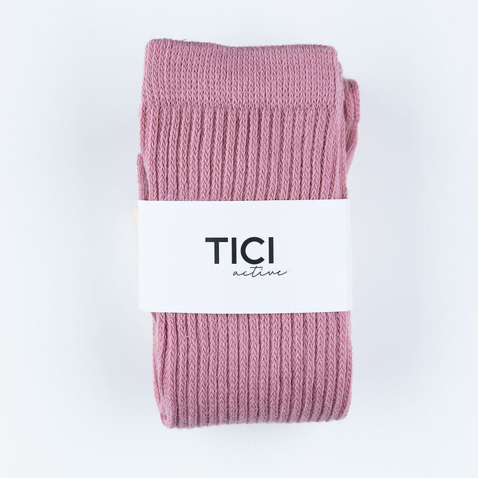 Pink ribbed socks with a white label featuring 'TICI' on a light gray grip socks  background