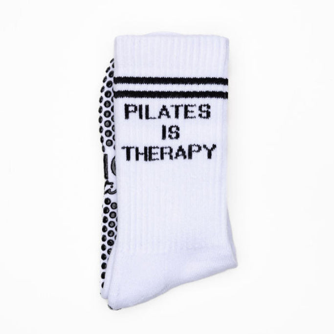 White pilates sock with 'Pilates is Therapy' text on a white background