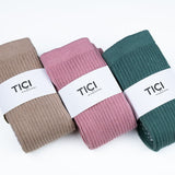 Three pairs of socks in brown, pink, and green with 'TICI' labels on a white background. tici active grip socks scrunch